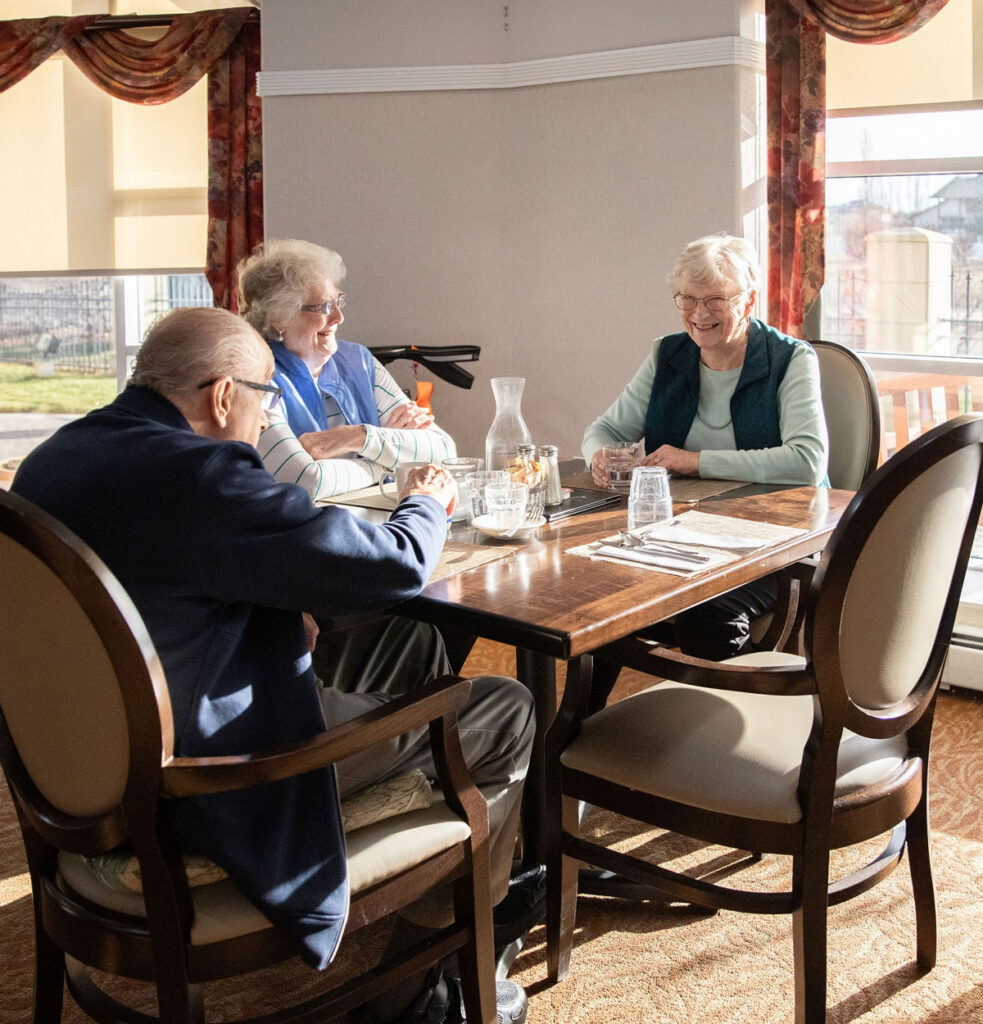 smiling residents at sunlit dining table