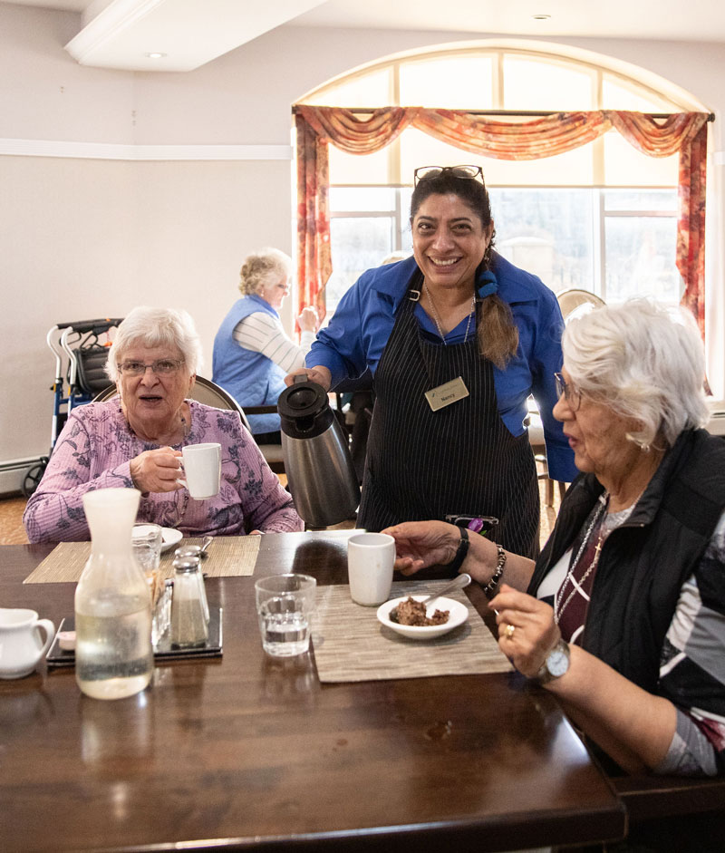 smiling team member serving residents coffee