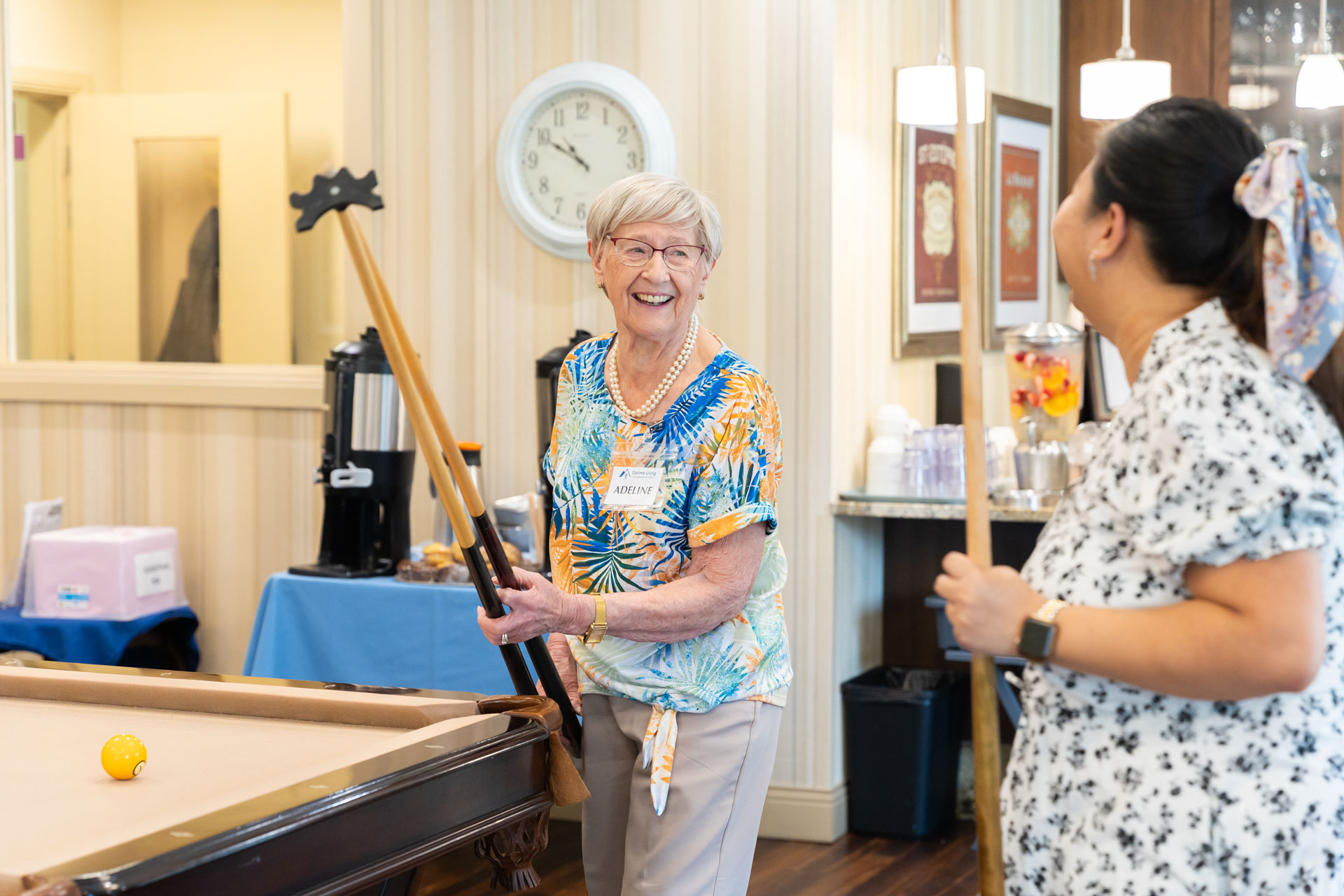 team member and resident playing pool